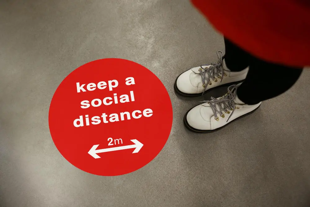 keep-social-distance-as-preventive-measure-during-coronavirus-outbreak-red-warning-sign-floor-front-woman-closeup